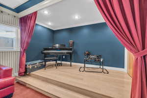 Living area with hardwood / wood-style floors and ornamental molding