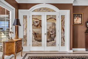 Details with tile patterned flooring, crown molding, and french doors