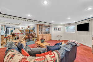 Carpeted living room featuring ornamental molding