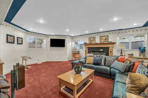 Living room with ornamental molding, carpet floors, and a tile fireplace