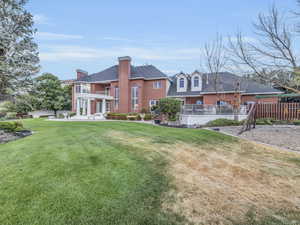 Back of house with a patio and a lawn