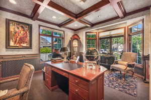 Office space featuring beamed ceiling, crown molding, dark carpet, and coffered ceiling