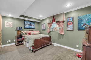 Carpeted bedroom with ornamental molding