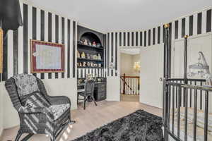 Bedroom with an inviting chandelier, light hardwood / wood-style flooring, and ornamental molding