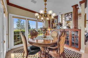 Dining space with ornamental molding, a wealth of natural light, and a chandelier