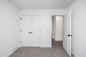 Unfurnished bedroom with carpet and a closet