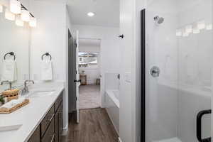 Bathroom with plus walk in shower, hardwood / wood-style flooring, and double sink vanity