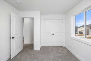 Unfurnished bedroom with carpet and a closet