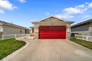 Single story home featuring a garage and a front lawn