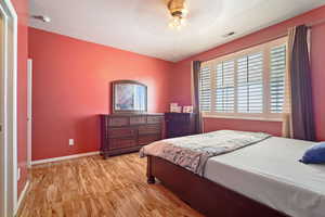 Bedroom featuring light hardwood / wood-style flooring, a textured ceiling, and ceiling fan