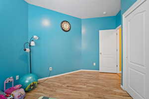 Exercise area with light hardwood / wood-style floors