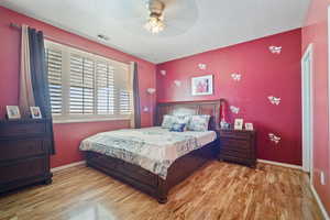 Bedroom featuring a textured ceiling, light wood-type flooring, and ceiling fan