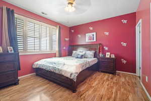 Bedroom featuring light hardwood / wood-style floors, a textured ceiling, and ceiling fan