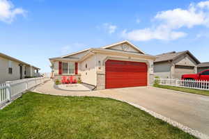 Single story home with a garage and a front lawn