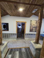 Hallway with wooden walls, wooden ceiling, vaulted ceiling, and hardwood / wood-style flooring