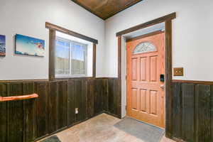 Foyer entrance featuring wooden walls