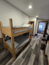 Bedroom featuring vaulted ceiling and dark hardwood / wood-style floors