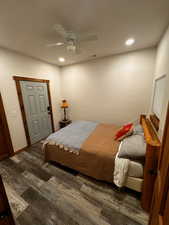 Bedroom with dark hardwood / wood-style floors and ceiling fan