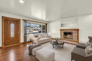 Living room featuring a stone fireplace and hardwood / wood-style floors