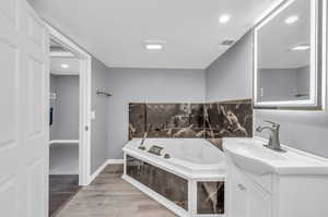 Bathroom featuring vanity, hardwood / wood-style flooring, and a bathtub