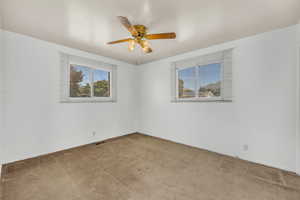 Carpeted empty room with ceiling fan