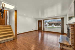 Living room with hardwood / wood-style flooring and a stone fireplace