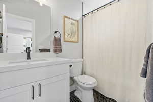 Bathroom featuring vanity, toilet, and tile patterned flooring