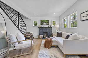 Living room featuring a brick fireplace and light wood-type flooring