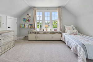 Adorable Bedroom featuring vaulted ceiling and light colored carpet