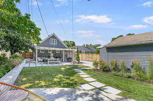 Rear view of property featuring a patio, an outdoor hangout area, and a yard