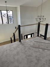 Stairs featuring hardwood / wood-style floors and an inviting chandelier