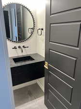 Bathroom featuring decorative backsplash, tile patterned floors, and sink