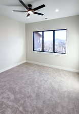 Unfurnished room with carpet, ceiling fan, and a mountain view