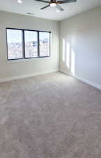 Unfurnished room featuring ceiling fan and light colored carpet