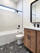 Full bathroom featuring tiled shower / bath, vanity, tile patterned flooring, and toilet