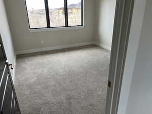 Empty room with light colored carpet and a wealth of natural light