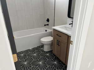 Full bathroom with vanity, shower / bath combination, toilet, and tile patterned floors