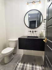 Bathroom featuring tile walls, decorative backsplash, vanity, and toilet