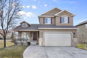 View of front facade with a front yard, a garage, and covered porch