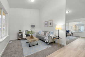 Living room with a healthy amount of sunlight and light hardwood / wood-style flooring