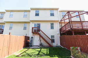 Rear view of property with a wooden deck and a lawn