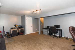 Carpeted office space featuring track lighting