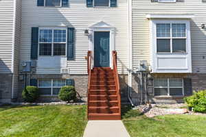 View of exterior entry featuring a lawn