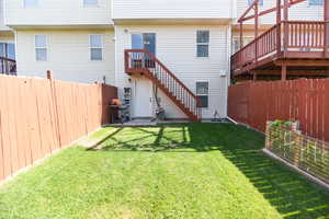 Back of house featuring a yard and a wooden deck