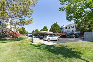 View of parking featuring a carport and a yard