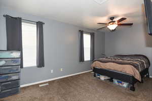 Carpeted bedroom featuring ceiling fan