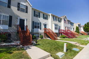 Townhome / multi-family property with a front lawn