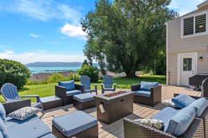 View of patio / terrace with an outdoor living space with a fire pit and a deck with water view