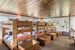 Carpeted bedroom featuring wooden ceiling