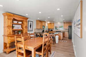 Dining space with light hardwood / wood-style flooring and sink